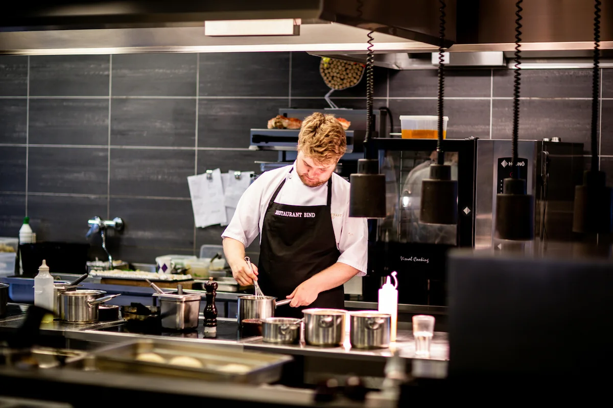 Chef en plena acción en la cocina de un restaurante, preparando creaciones innovadoras.