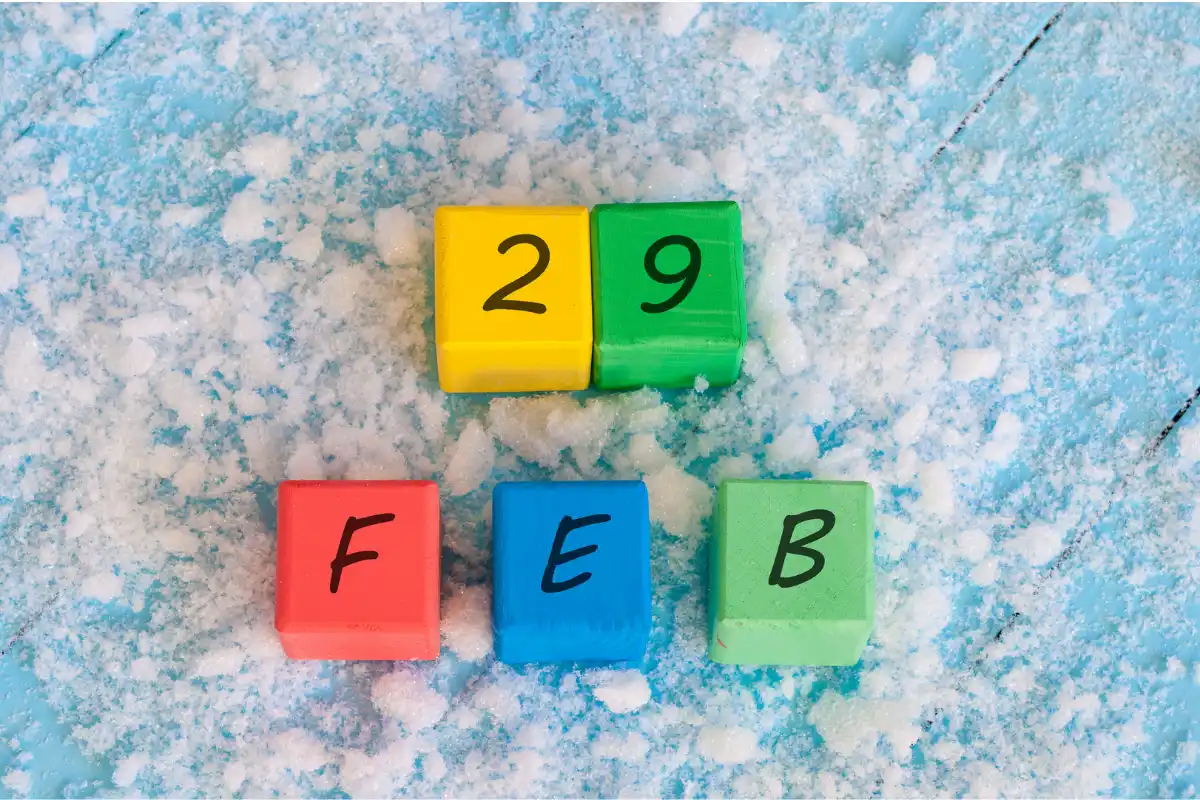 Bloques de colores con los números "29" y las letras "FEB" sobre nieve, anunciando una promoción de croquetas para los nacidos el 29 de febrero.