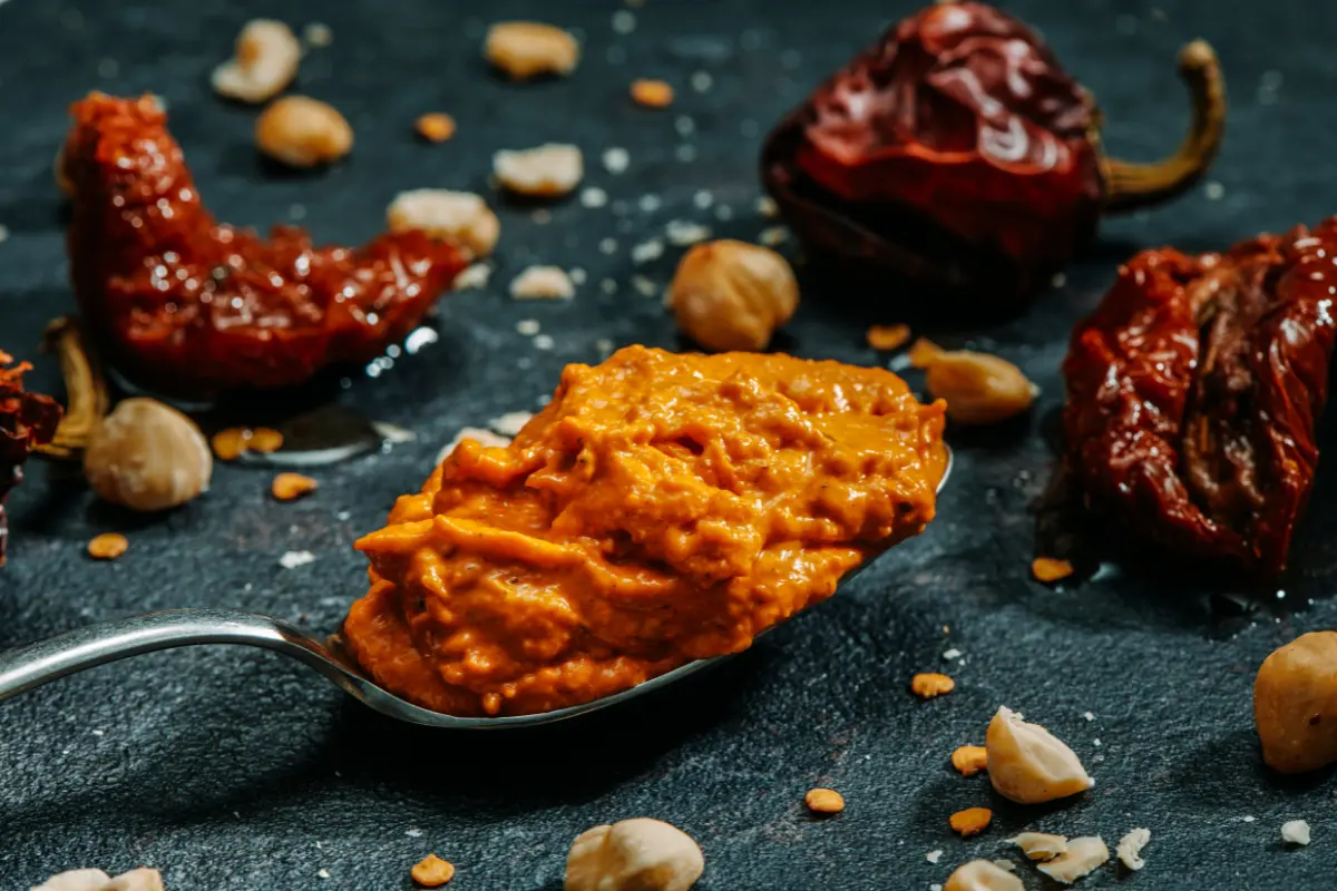 Cucharada de salsa romesco casera con almendras y avellanas, perfecta para acompañar croquetas.